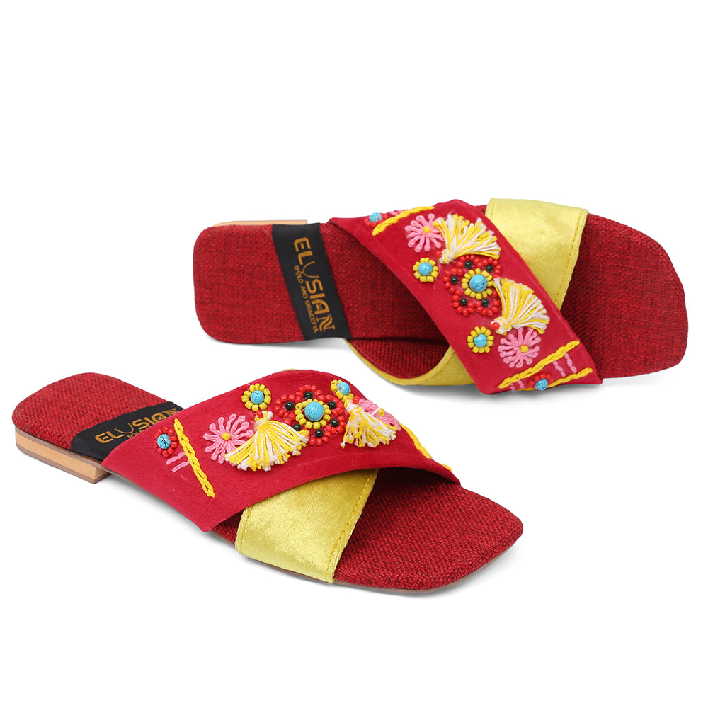 A pair of red and yellow flats with handmade detailing and the brand name 'ELYSIAN' on the strap.