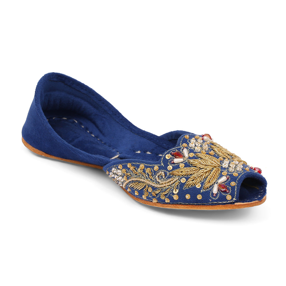 A blue velvet shoe with intricate embroidery and a wooden sole, showcasing a snug fit and padded design.