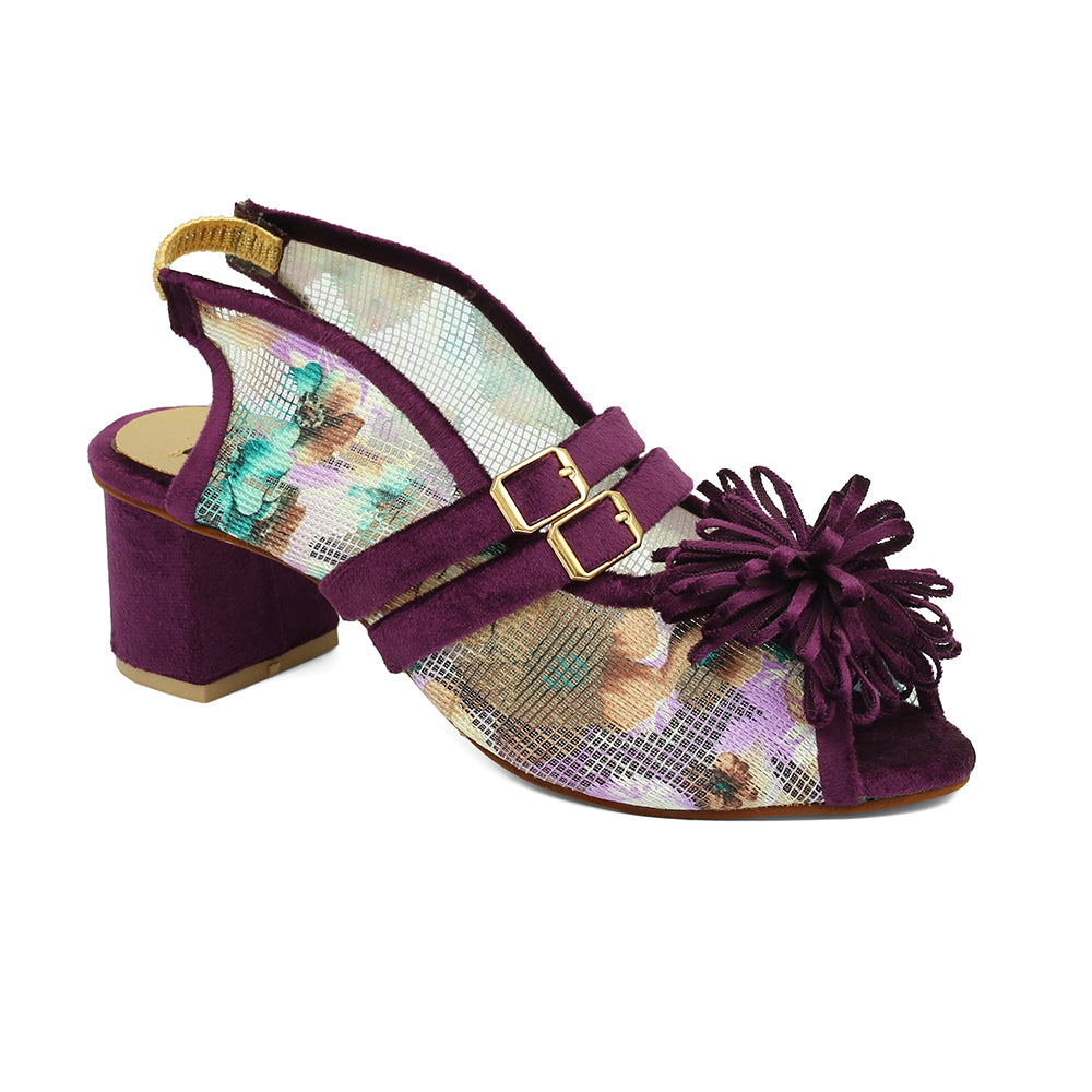 A pair of purple open-toe platform wedges with a floral buckle design and regzine embellishments.