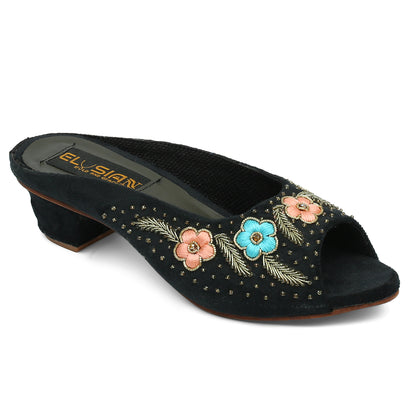 A pair of black open-toe platform wedges with embroidery detailing and a removable ankle strap.